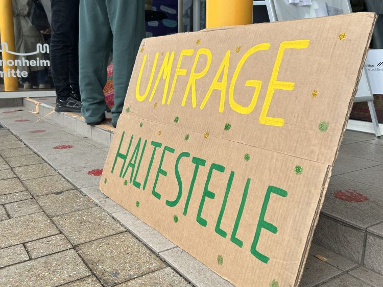 Eine Pappe, auf der "Umfrage Haltestelle" steht